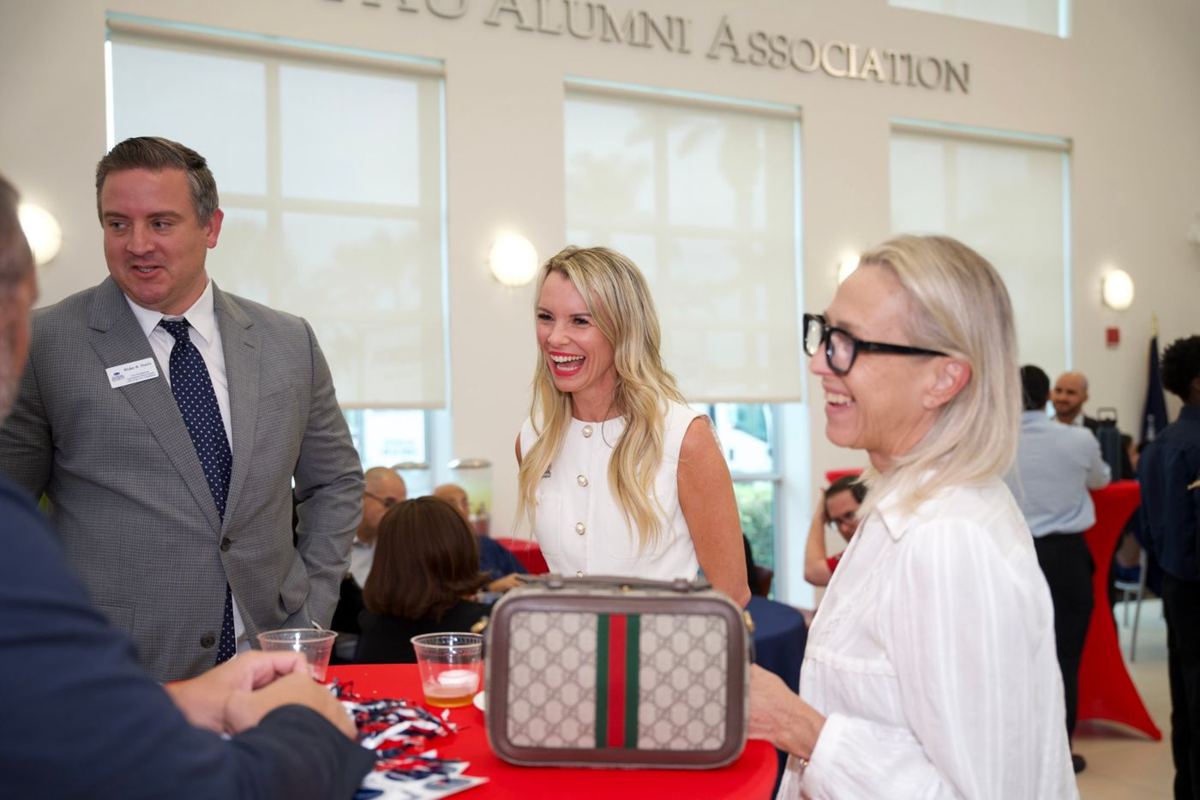 Guests laughing at an FAU Alumni Association reception